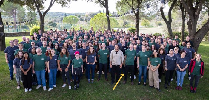 A crowd of people looking at the camera, with an arrow pointing to one person